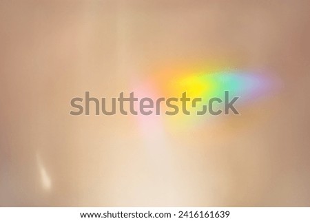 Defocused abstract beige background with rainbow flare from sunlight, holiday backdrop, celebration wallpaper. Colorful sparkle sun glare, Glittering aesthetic textured photo pattern, trend color