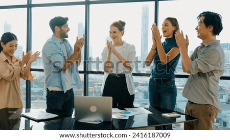 Professional business team clapping hand together with document scatter around at business meeting room with cityscape view. Businesspeople celebrate success. Represented cooperation. Tracery Royalty-Free Stock Photo #2416187009