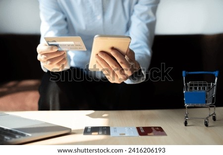 Asian girl shopping online holding credit and using smartphone enter their card number in the mobile phone app to purchase and payment in internet store.