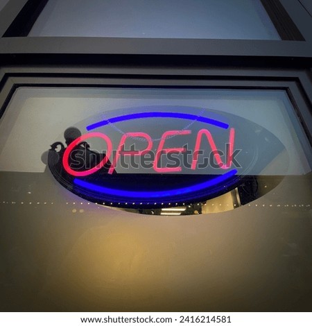 Neon open signage on a business storefront on Rideau Street in downtown Ottawa Ontario Canada.