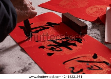 An old calligrapher writes couplets during the Chinese Year of the Dragon.
Translation: The auspicious energy brings auspiciousness and the wealth is abundant.