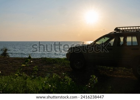 Phuket Thailand January 22,2024:Brown American SUV Jeep Grand Cherokee WJ 2002 on the beach sunset sky background in Phuket island Thailand,Travel and camping concept transportation background Royalty-Free Stock Photo #2416238447