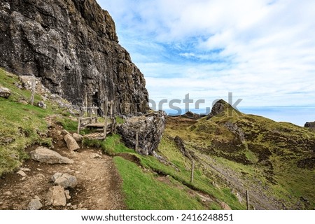 A Scenic Pathway Along Rugged Mountain Cliffs Royalty-Free Stock Photo #2416248851