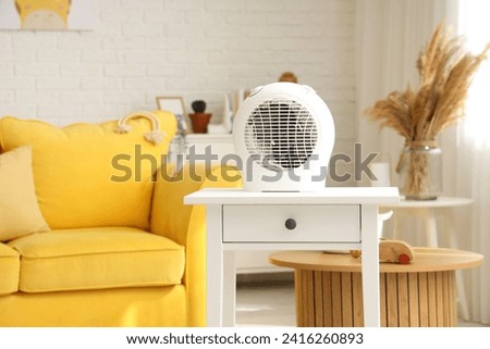 Electric fan heater on table in children's room Royalty-Free Stock Photo #2416260893