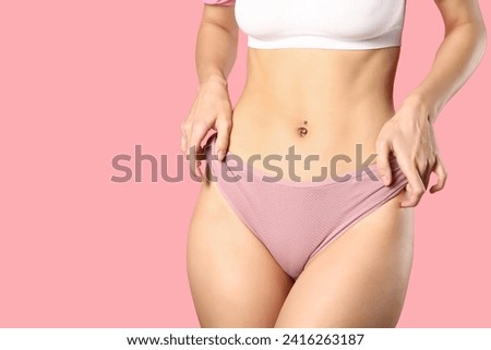 Young woman in panties on pink background Royalty-Free Stock Photo #2416263187
