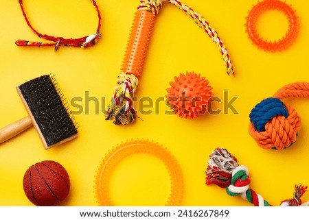 Pet toys on yellow background studio shot