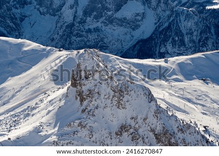 Ski resort in the Dolomites. Mountain recreation place. Ski slopes in the Dolomites on a clear sunny day. Alpine skiing sport and recreation. Royalty-Free Stock Photo #2416270847