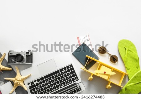Composition with modern laptop, passport, ticket and beach accessories on light background