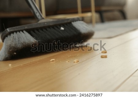 Home cleaning. Close up of woman doing housework, holding a broom and sweeping floor	 Royalty-Free Stock Photo #2416275897