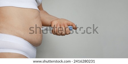 Female model patient making Semaglutide Injection Pen in her Stomach. Semaglutide Injection Diabetes Drug Being Used For Weight Loss.  Royalty-Free Stock Photo #2416280231