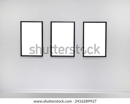Three empty vertical picture frames hanging on white wall, Wall art mockup set of 3 posters, blank space frame modern interior style, minimalist with clipping path