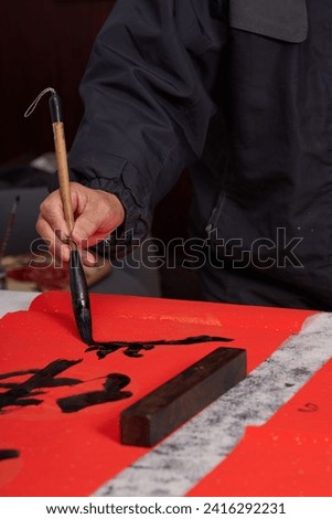 An old calligrapher writes couplets during the Chinese Year of the Dragon.
Translation: May you welcome the Spring and good luck in the Year of the Dragon.