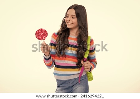 Teenage girl with lollipop, child eating sugar lollipops, kids sweets candy shop. Excited teenager girl. Happy girl face, positive and smiling emotions.