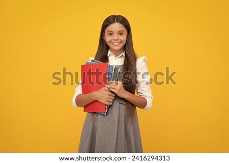 Teen girl pupil hold books, notebooks, isolated on yellow background, copy space. Back to school, teenage lifestyle, education and knowledge. Happy girl face, positive and smiling emotions.