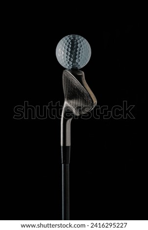 photo of a golf stick with the focus set on the golf ball on the stick and with a dark background