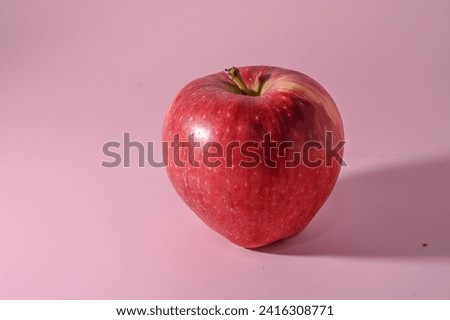 red apple on a pink background