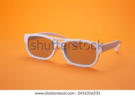 orange background white glasses stock photo
