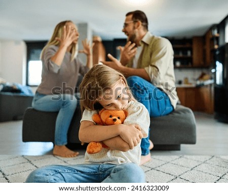 Portrait of a sad little girl and parents in conflict, disagreement or fight in the living room at home. Family, divorce and husband in argument with wife and unhappy child  in depression
 Royalty-Free Stock Photo #2416323009