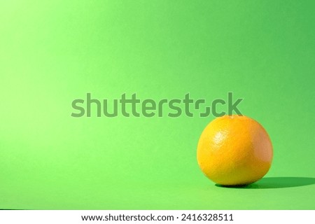 Single grapefruit citrus fruit against a seamless green background
