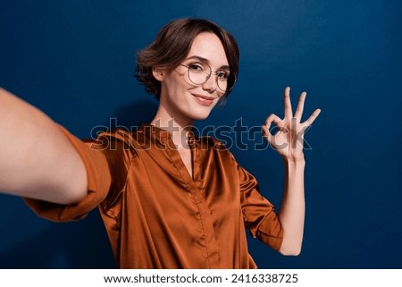 Photo portrait of attractive young woman selfie camera okey symbol wear trendy brown blouse isolated on dark blue color background