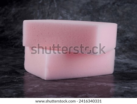Melamine sponge on a gray printed background. Royalty-Free Stock Photo #2416340331