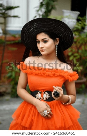Portrait of young beautiful modern Indian woman wearing western outfit with black straw hat posing fashionable in a blurred background. Lifestyle and Fashion. Royalty-Free Stock Photo #2416360451