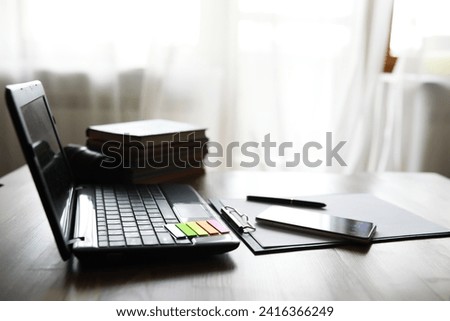 Hands using laptop and phone for online shopping, close up clean image in front of window in soft light