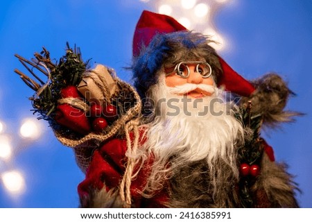 Santa Claus doll on a blue background with stars and snow