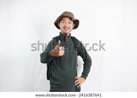Happy asian man shows thumb up as a good hand sign isolated on white background.
