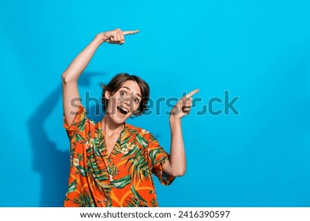 Photo of positive nice girl wear trendy outfit two arms above head demonstrate empty space offer poster isolated on blue color background