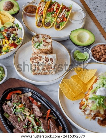 Several food dishes are served on the dining table. Royalty-Free Stock Photo #2416392879