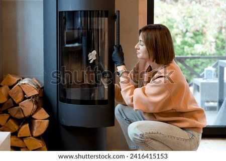 Young woman cleaning fireplace. Preparation for cold winter	
