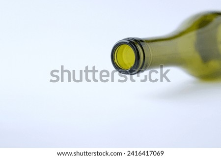The neck of an empty bottle is on a white background. Green glass. Wine bottling technology. Copy space.