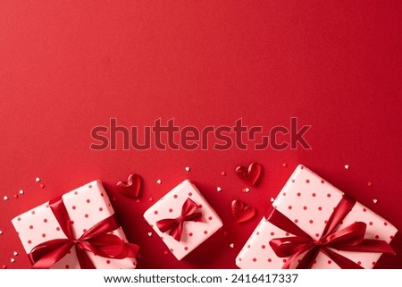 Valentines Day gifts with red hearts on red table. Top view, flat lay. Royalty-Free Stock Photo #2416417337