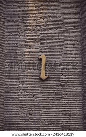 a rough concrete wall with a gold unit on it