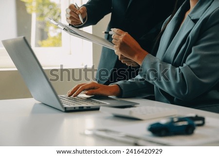 Closeup asian male people car salesman or sales manager offers to sell a car and explains and reads the terms of signing a car contract and insurance. Royalty-Free Stock Photo #2416420929