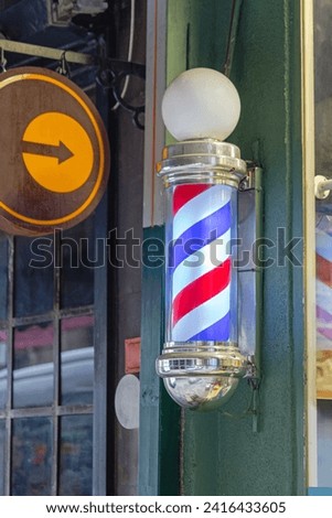 Rotating Spiral Lamp in Front of Barber Shop Pole Sign