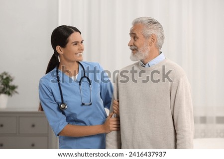 Health care and support. Smiling nurse with elderly patient in hospital