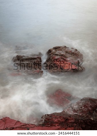 splashing of a sea water as a wave hitting the rock at seaside
