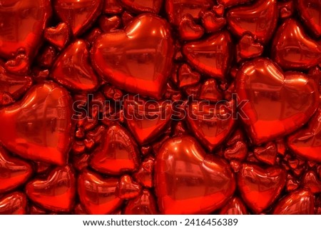 Background of red heart balloons. Festive photo zone for Valentine's Day. Background for cards, banners, invitations, congratulations, volumetric 3D shiny glossy heart-shaped balls Royalty-Free Stock Photo #2416456389