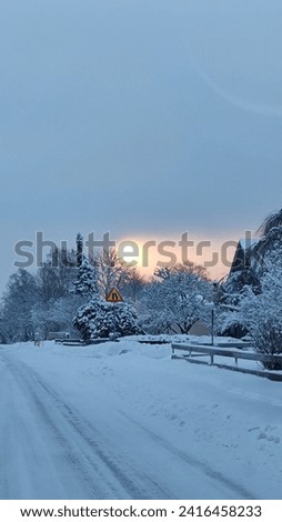 snowy road and village with beautiful sunrise im Sweden 