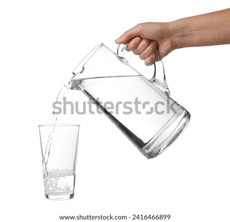 Woman pouring water from jug into glass on white background, closeup Royalty-Free Stock Photo #2416466899