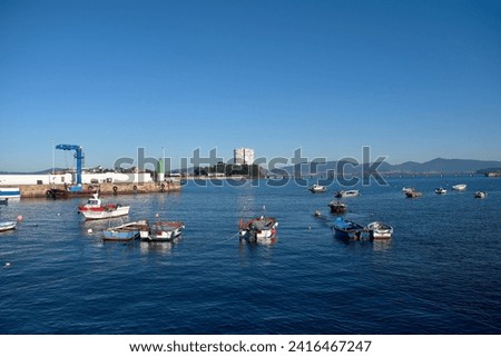 Small artisanal and sport fishing boats are the most common in Canido, we also see the port and the Toralla Island building in the background