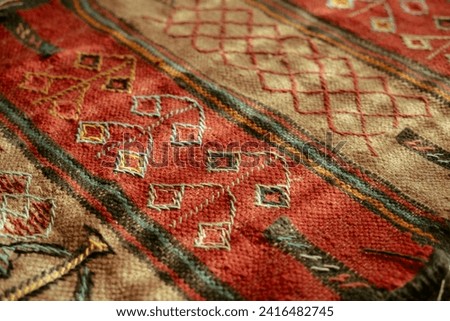 A close-up photo of a pattern and design on an Iranian rug with sunlight shining on it.