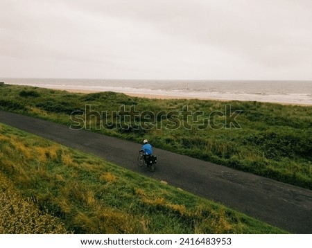 Aerial shot of a female cyclist crossing fields in England. High quality photo