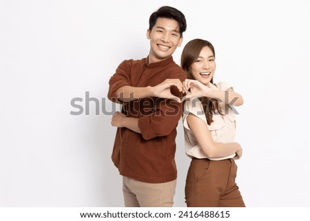 Young Asian couple making heart sign isolated on white background