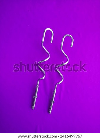 steel whisks for a mixer on a purple background
​