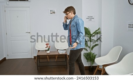 Cool, young hispanic man nervously talking on his phone, pacing in a busy waiting room. Royalty-Free Stock Photo #2416503153