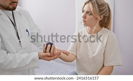 Physiotherapist man using spikey ball on patient woman's arm in white rehab room Royalty-Free Stock Photo #2416516157