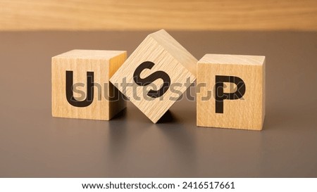 three wooden blocks with the abbreviation USP - Unique Selling Proposition symbolizes the distinct and compelling attributes that set a product, service, or business apart from others in the market.